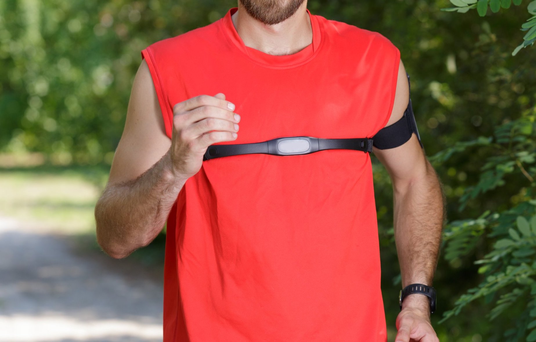 Man wearing chest strap over red tshirt