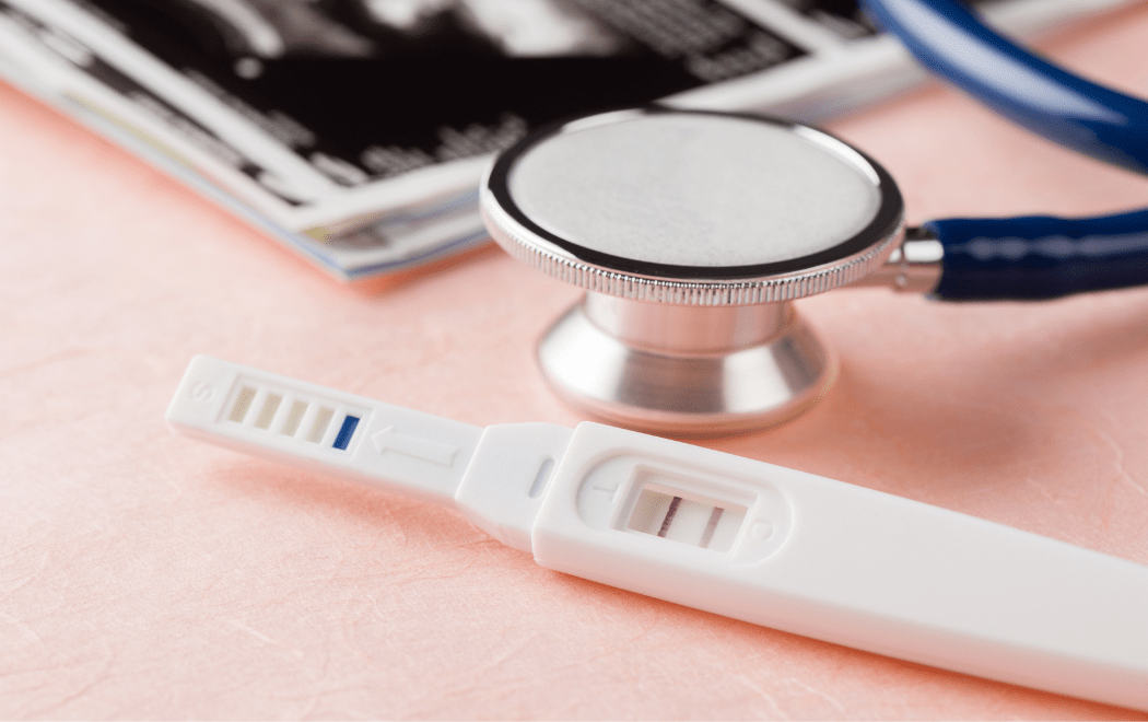 Close up of a pregnancy test and a stethoscope