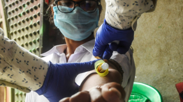 A health worker collects a blood sample from a police official for antibodies test of COVID-19 coronavirus, in Kolkata on August 23, 2020. (Photo by Dibyangshu SARKAR / AFP)
